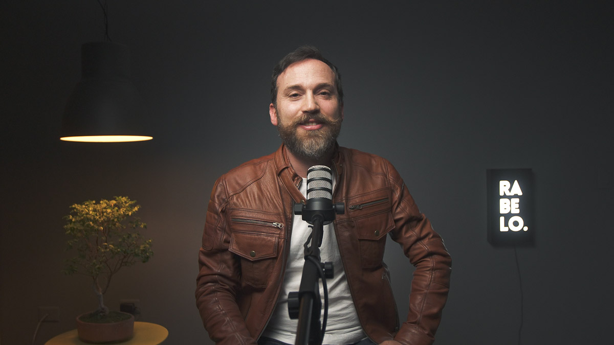 Retrato de Pablo Rabelo, creador de Rockcast Podcast, posando con su chaqueta de cuero en el estudio de grabación.